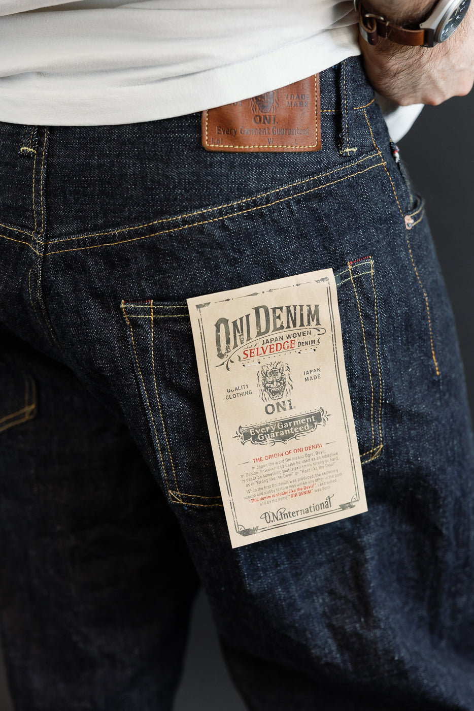 Close-up of back pocket showing ONI Denim selvedge jeans tag, male model, athletic build