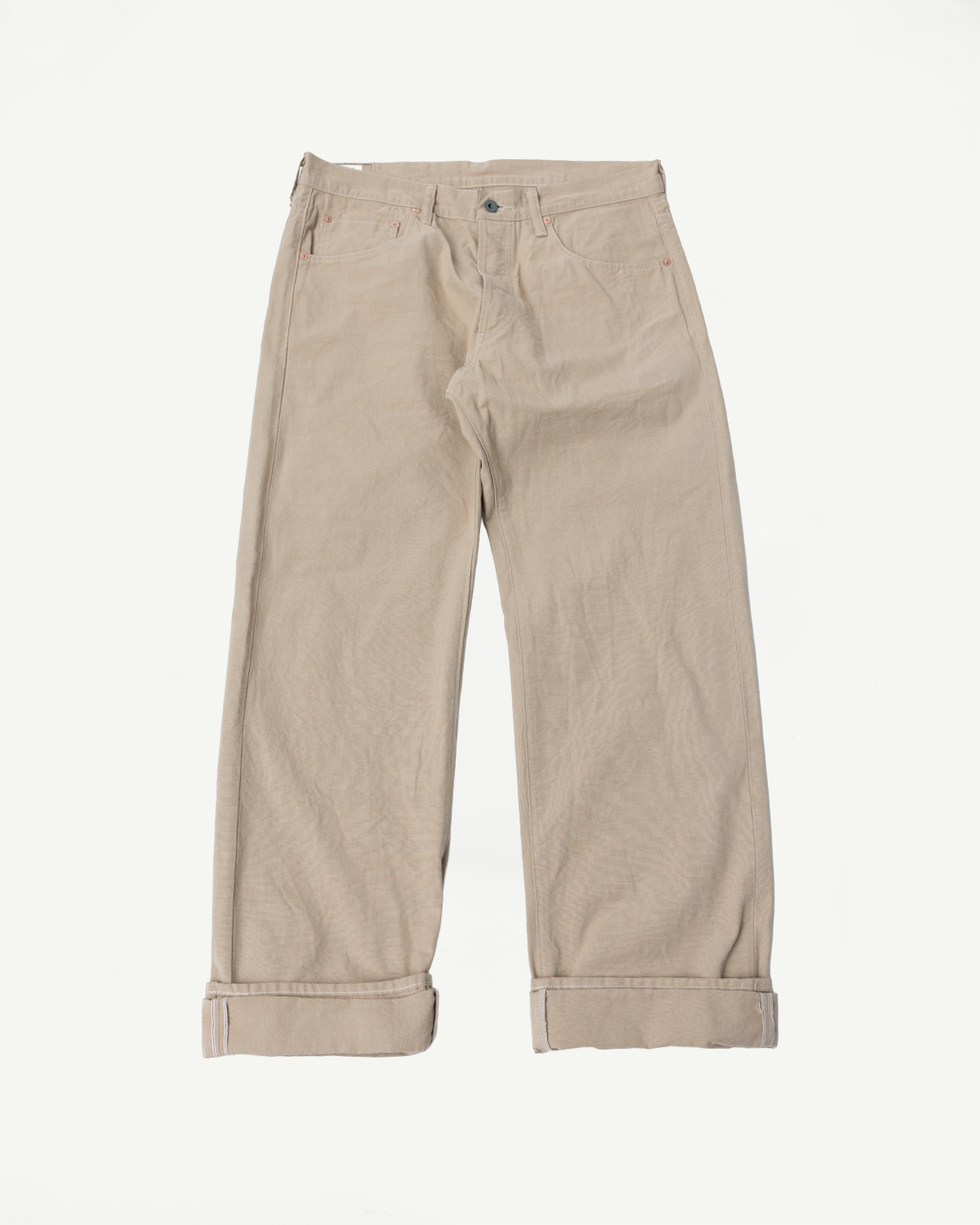 Front view of beige selvedge pants with cuffed hems, button fly, and classic pockets