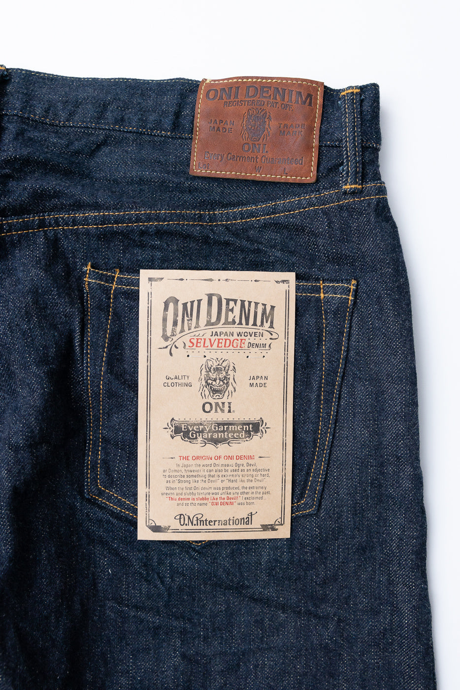 Close-up of ONI Denim selvedge jeans back waistband, showing leather patch and paper tag details