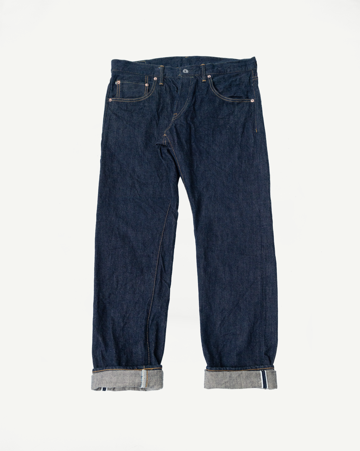 Front view of selvedge denim jeans with cuffed hems, showcasing texture and stitching details.
