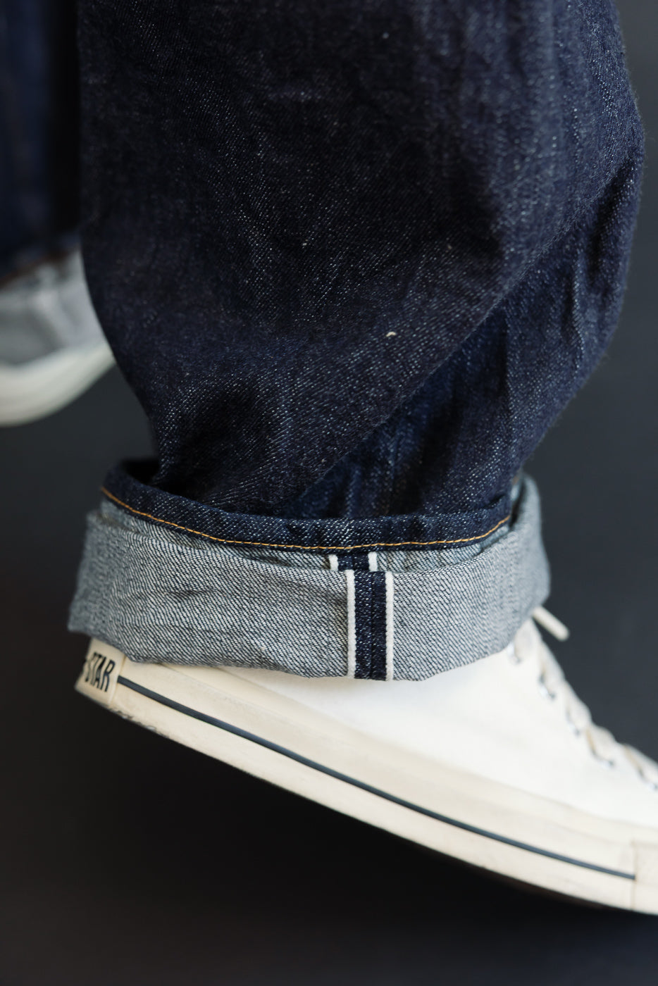 Close-up of cuffed selvedge denim jeans on a male model (5'9