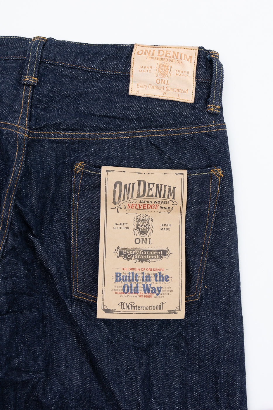 Close-up of the back of Oni Denim jeans showing the leather waist patch and pocket label.
