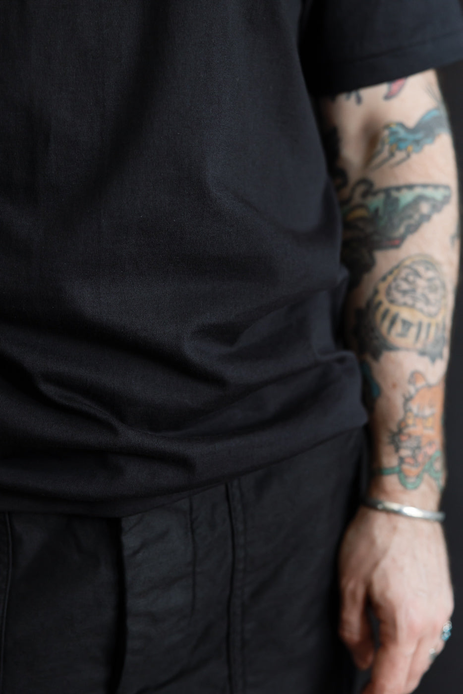 Close-up of black t-shirt lower front on male model, 5'9