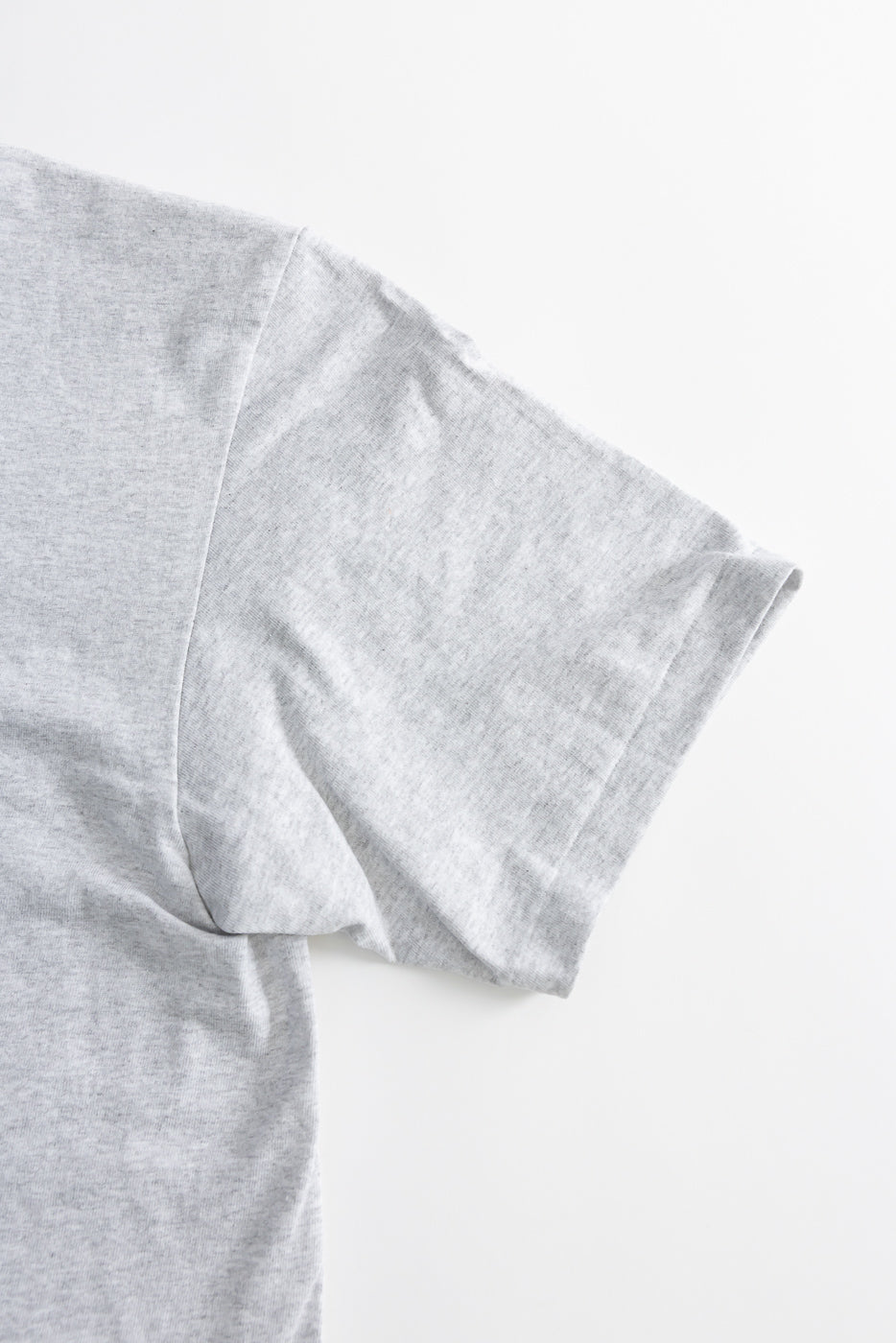 Close-up of heather grey t-shirt right sleeve, flat lay, front side, showing fabric texture