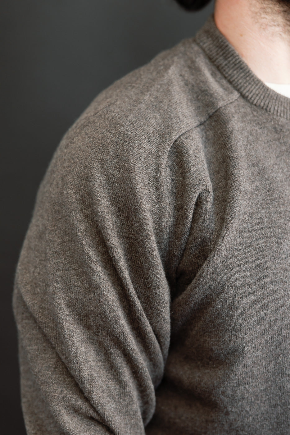 Close-up side view of a grey knit sweater on a 5'9