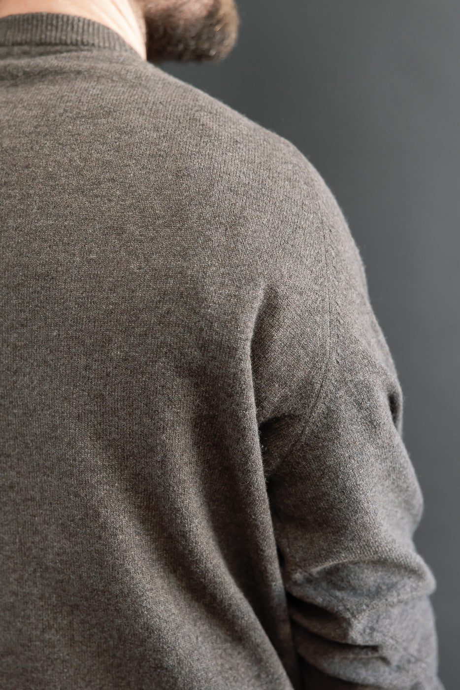 Close-up back view of a brown knit sweater on a male model, 5'9