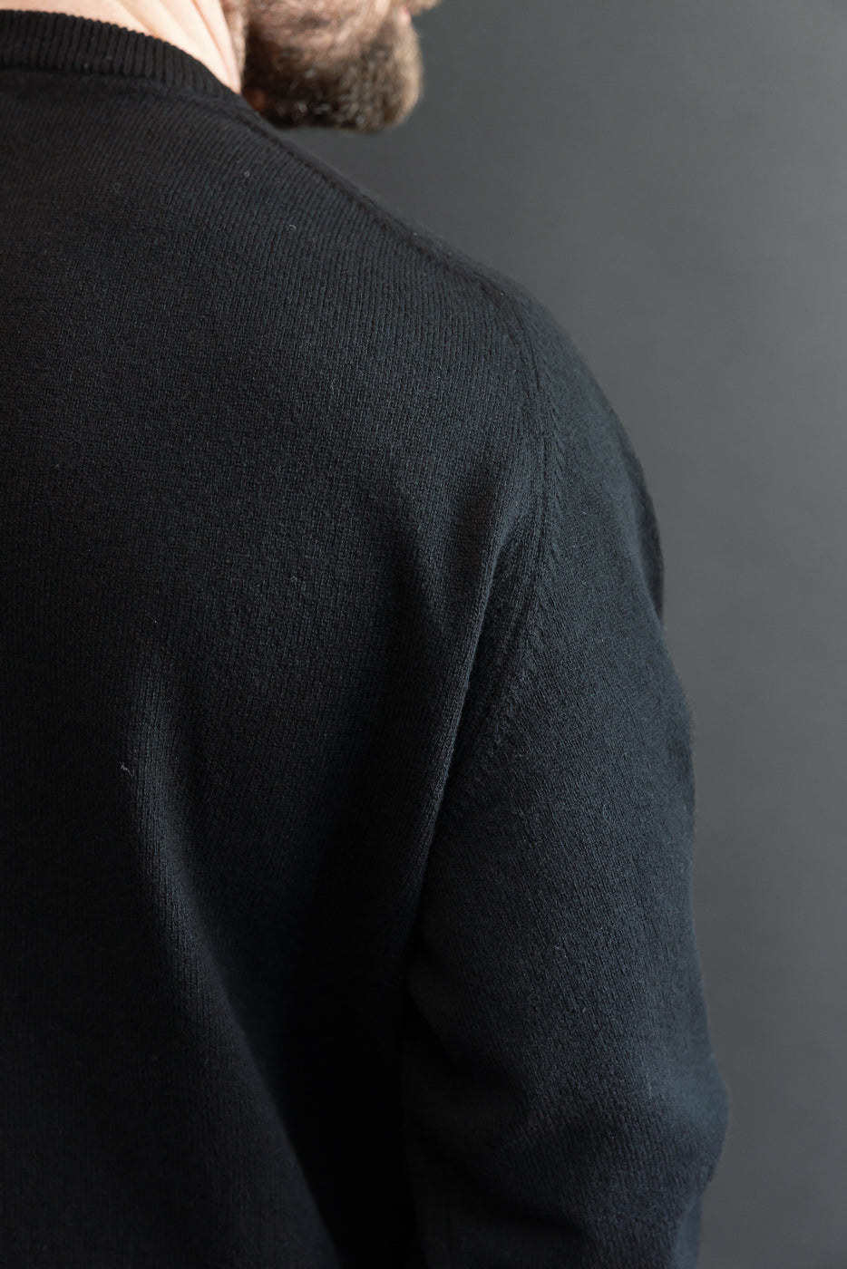 Close-up of back and shoulder of a black knit sweater on a 5'9