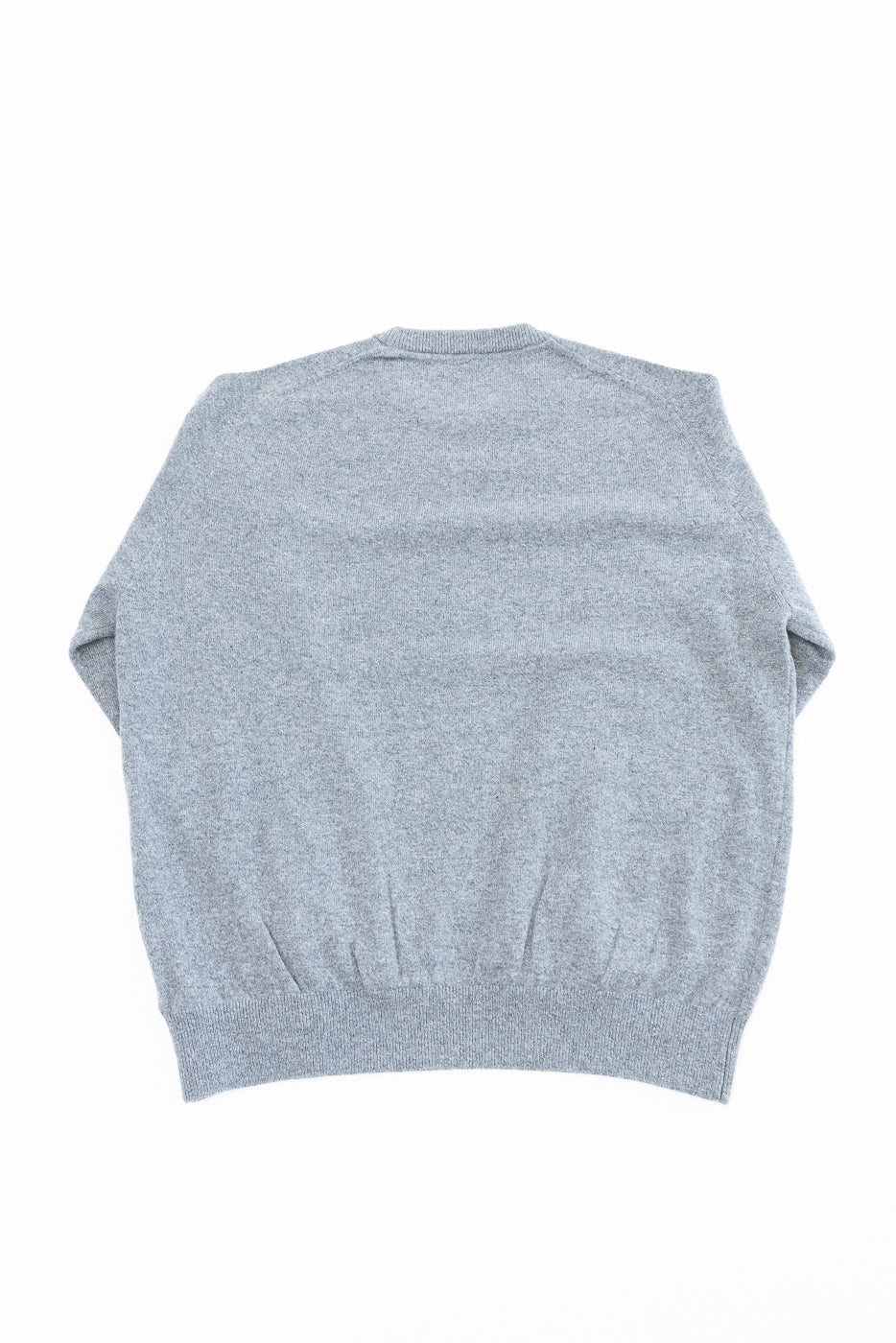 Flat lay showing the back of a grey knit sweater with a ribbed hem and cuffs.