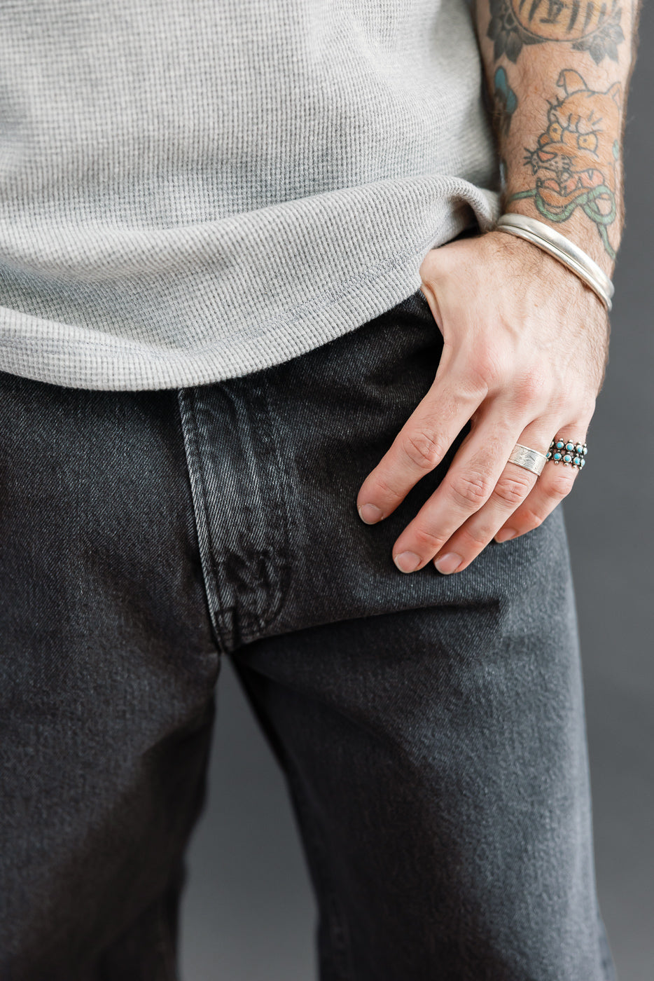 Close-up of the front waist and pocket of black denim jeans on a 5'9