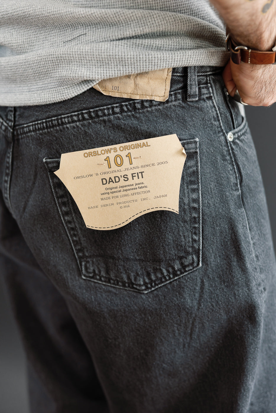Close-up of the back right pocket of black denim jeans featuring an Orslow 101 Dad's Fit tag.