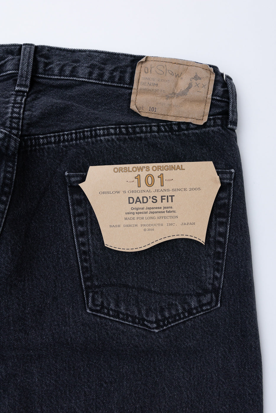 Close-up of the back right pocket of OrSlow 101 Dad's Fit jeans showing the fabric and tag details.