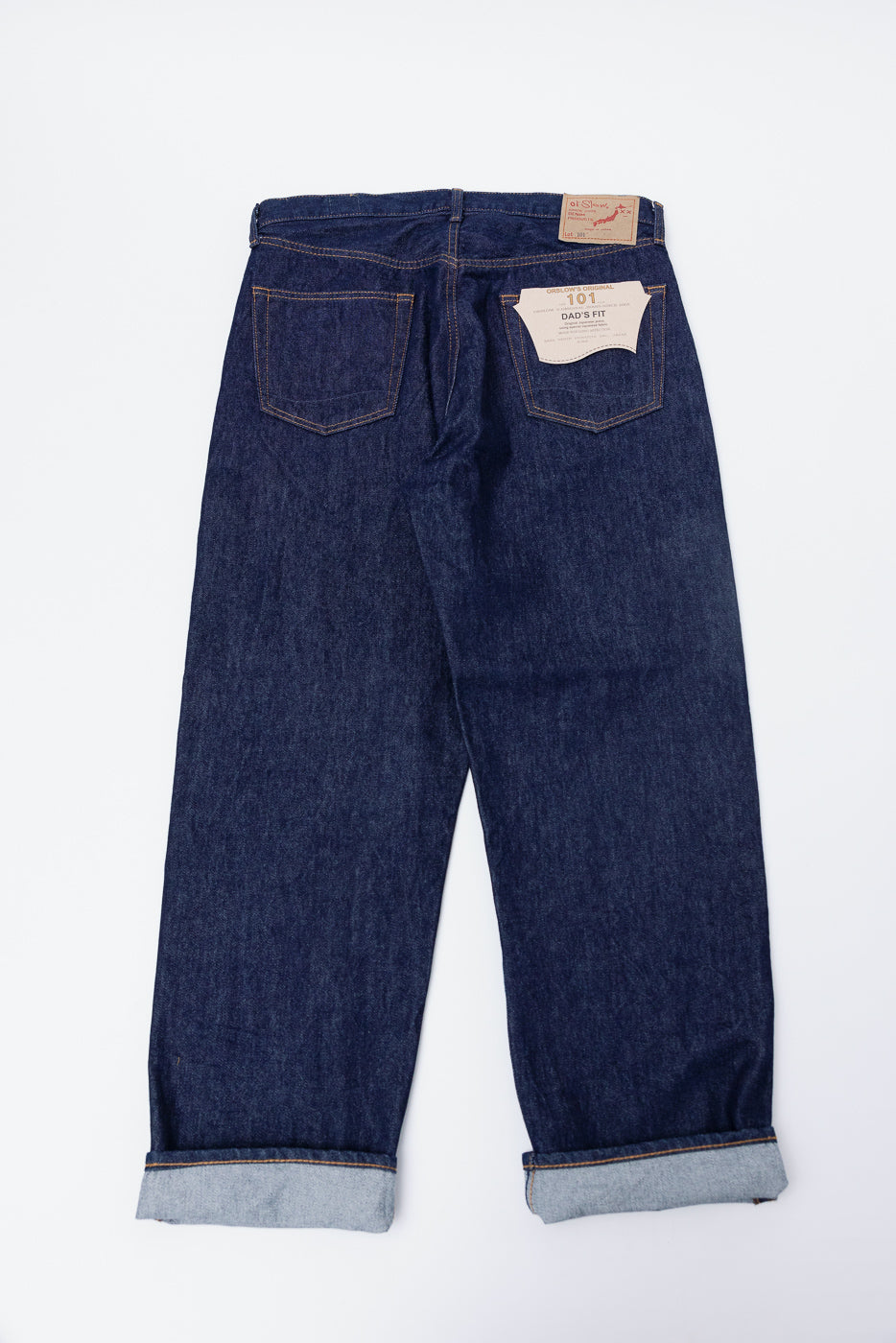 Flat lay of orSlow Dad's Fit selvedge denim jeans, back side, showing pockets and tags.
