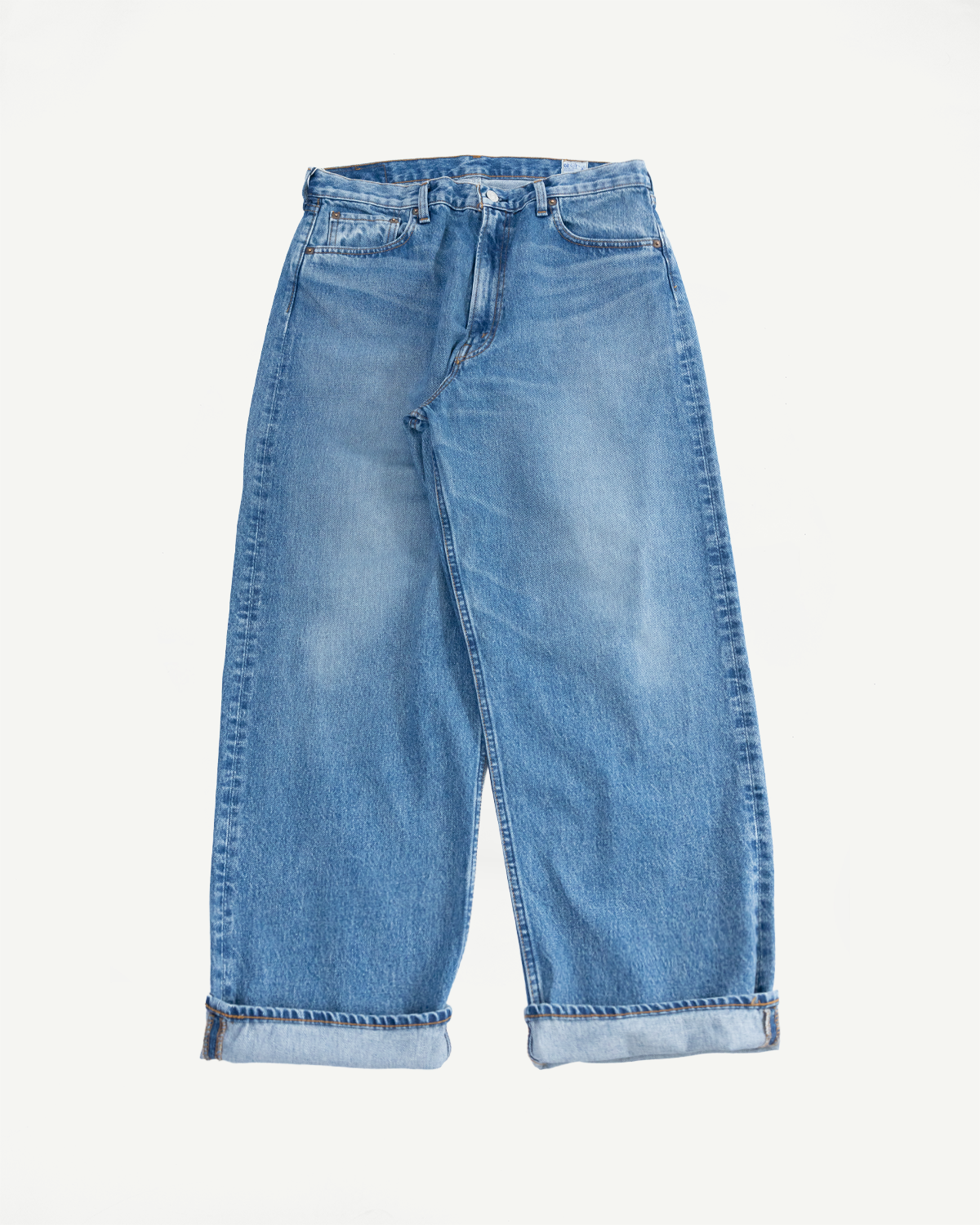 Flat lay front view of light wash wide-leg jeans with cuffed hems, selvedge denim detail
