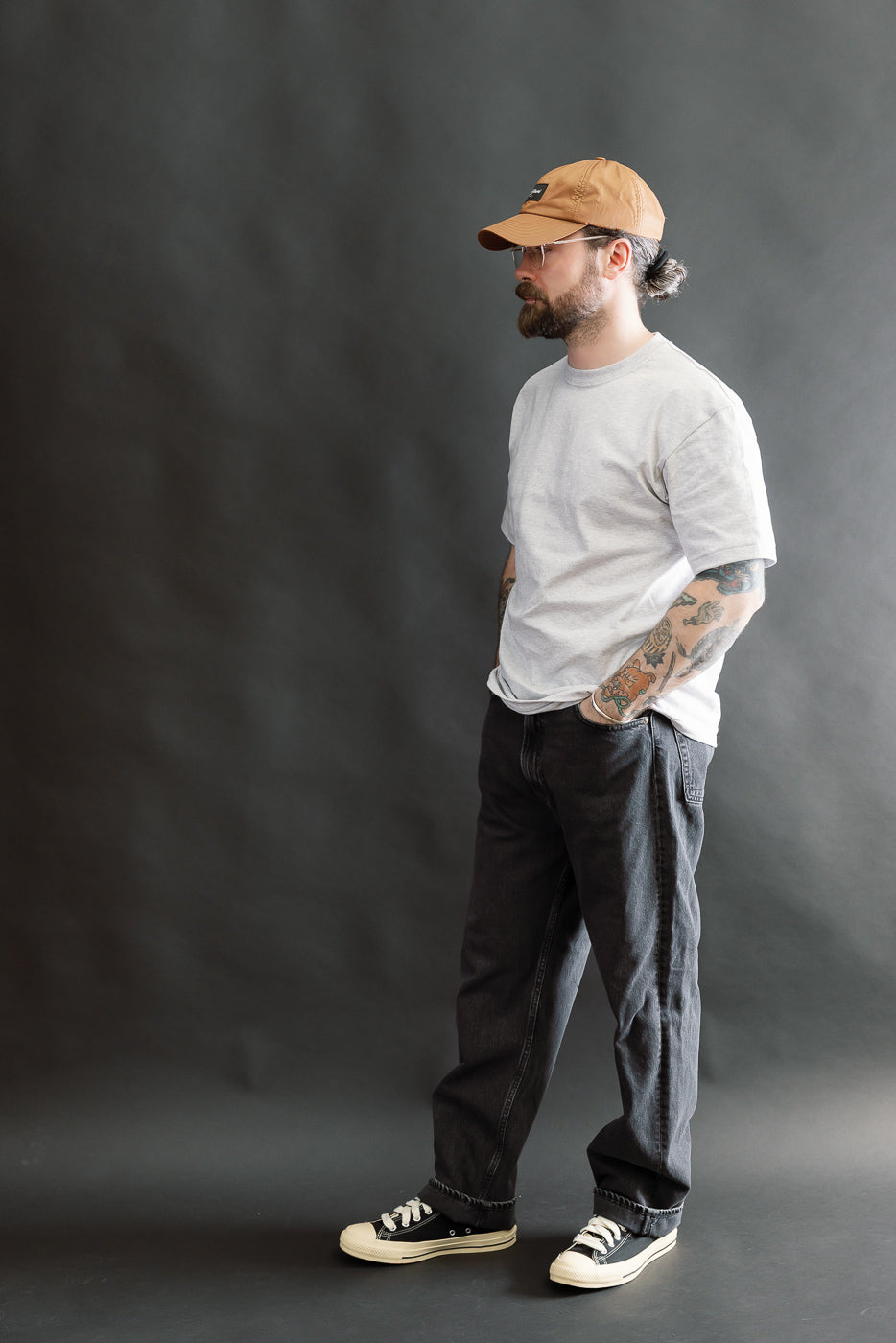 A bearded man in profile wears the 01-1010W-D61S - 101 Dad’s Fit Denim - 90s Black Stone, showcasing their relaxed, vintage-inspired silhouette with a stonewashed finish.
