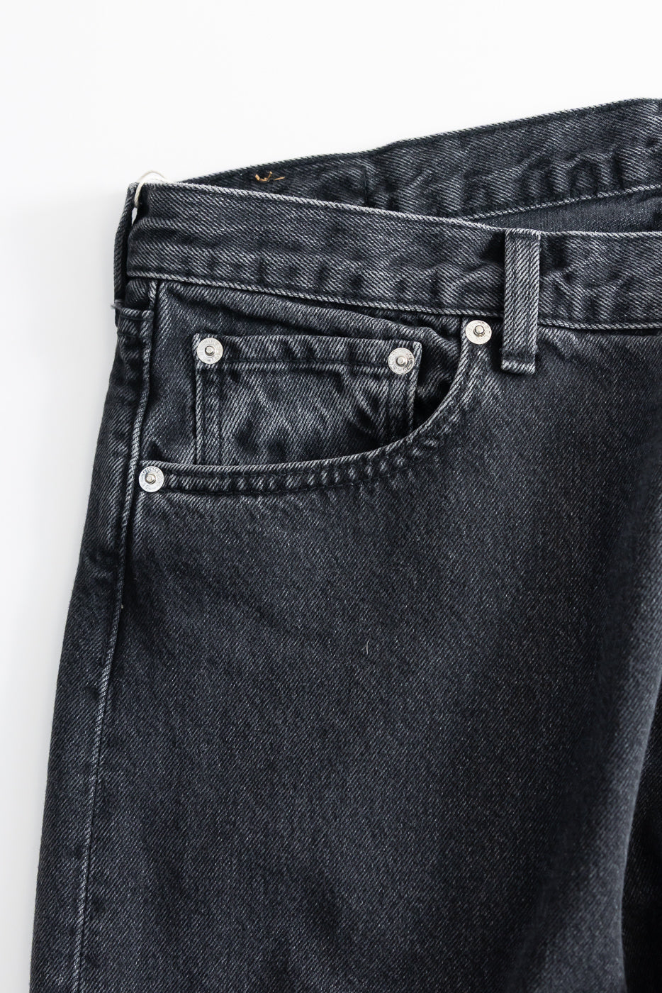 Close-up of the 01-1010W-D61S - 101 Dad’s Fit Denim - 90s Black Stone, highlighting the waistband, belt loop, and front pocket with metal rivets, showcasing the relaxed, vintage-inspired cut.