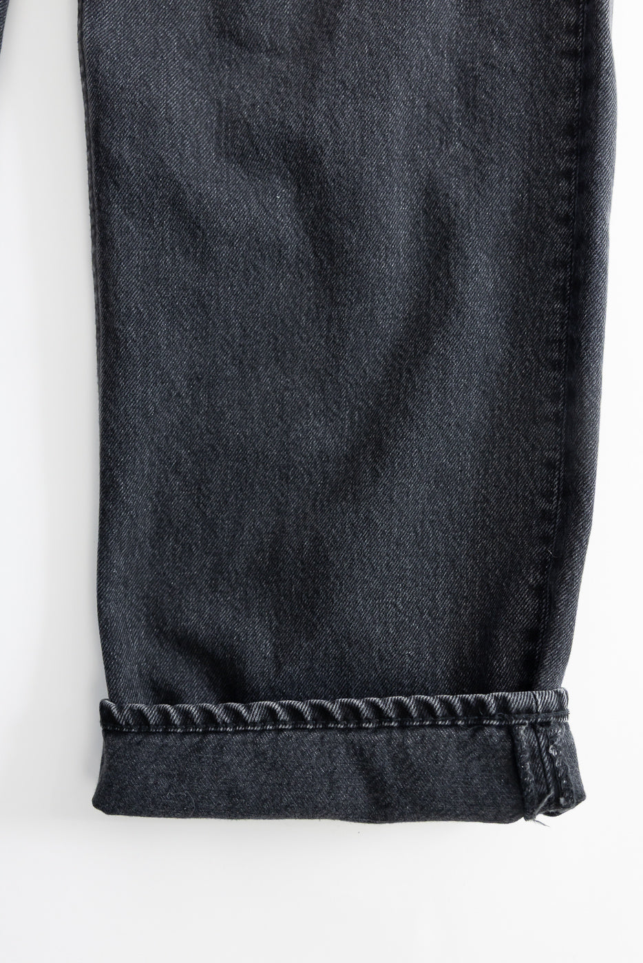 Close-up of the 01-1010W-D61S - 101 Dad’s Fit Denim - 90s Black Stone jeans, showing a cuffed hem of dark stone-washed denim, emphasizing the relaxed fit and subtle faded grey tones.