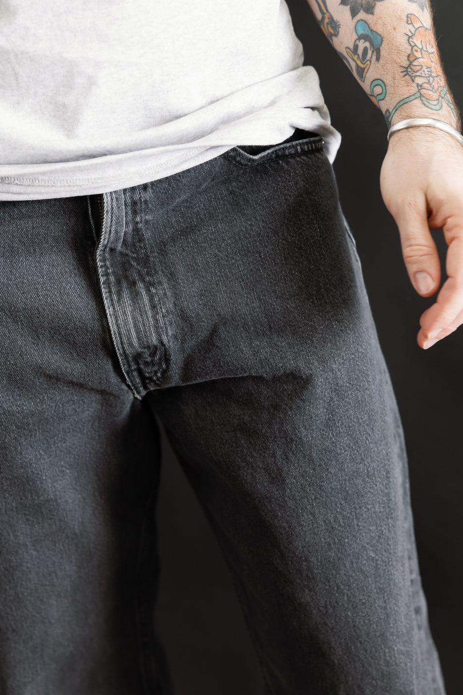 Close-up of the 01-1010W-D61S - 101 Dad’s Fit Denim - 90s Black Stone, showcasing the relaxed fit and stone-washed texture on dark denim, with a subtle faded effect around the crotch area.