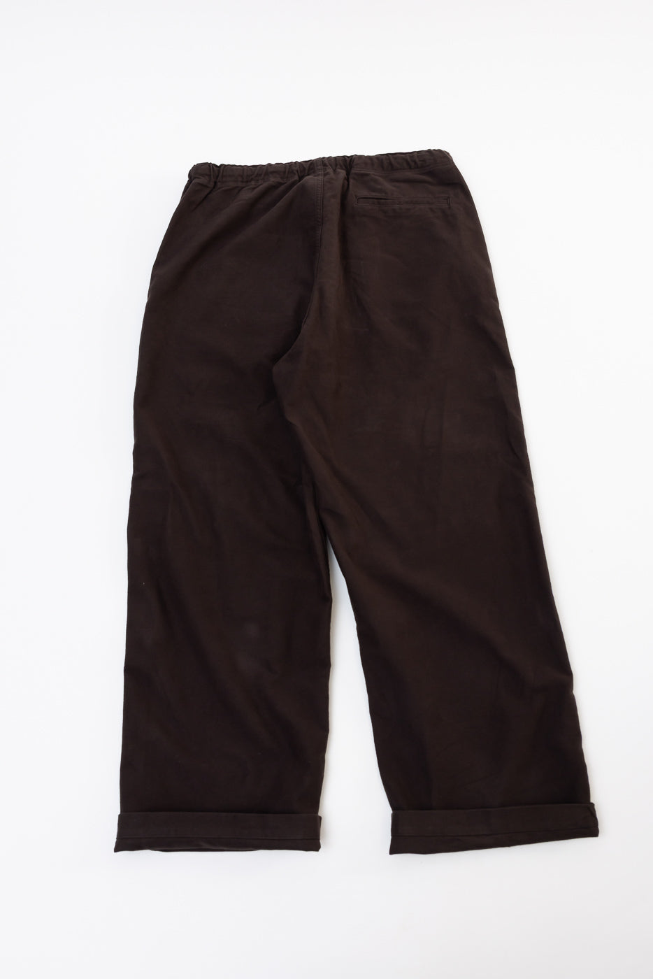 Back view flat lay of dark brown wide-leg trousers with an elastic waistband and cuffed hems.