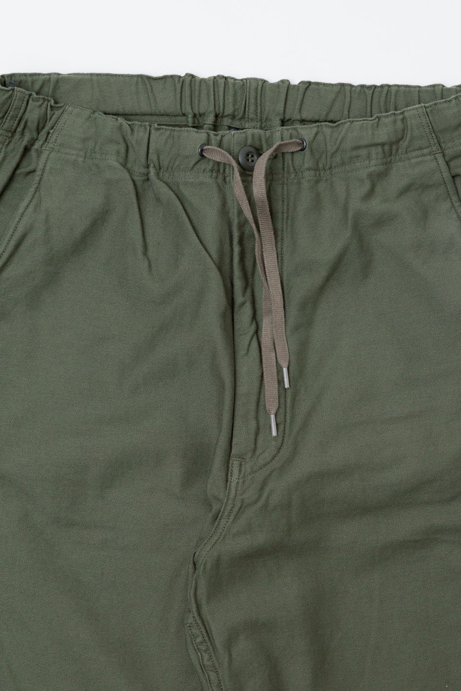 Close-up of Orslow dark olive New Yorker wide fit pants, front waistband, button, and drawstring detail.