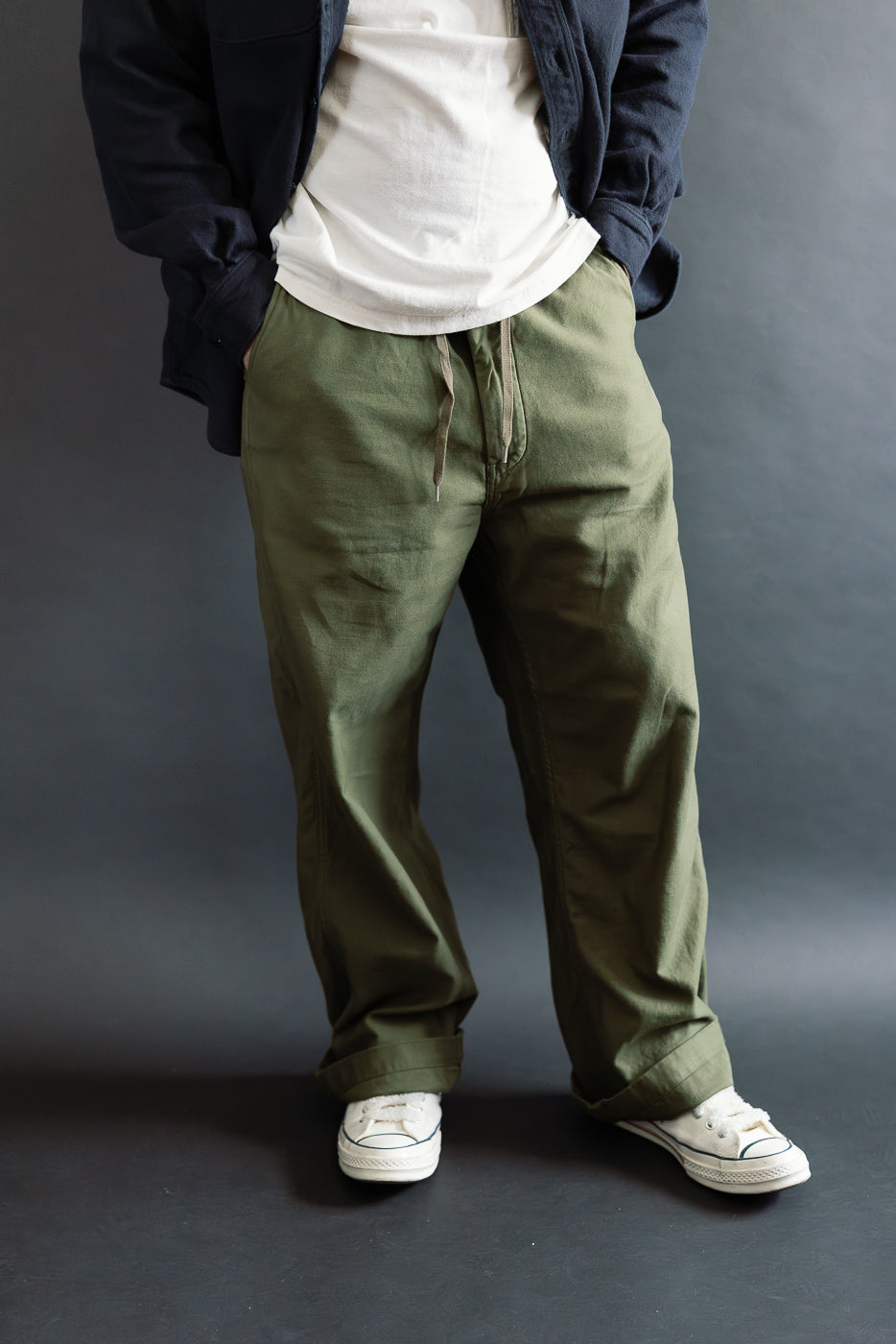 Front view, on-body shot of men's wide-fit dark olive pants, drawstring waist, modeled by male, 5'9