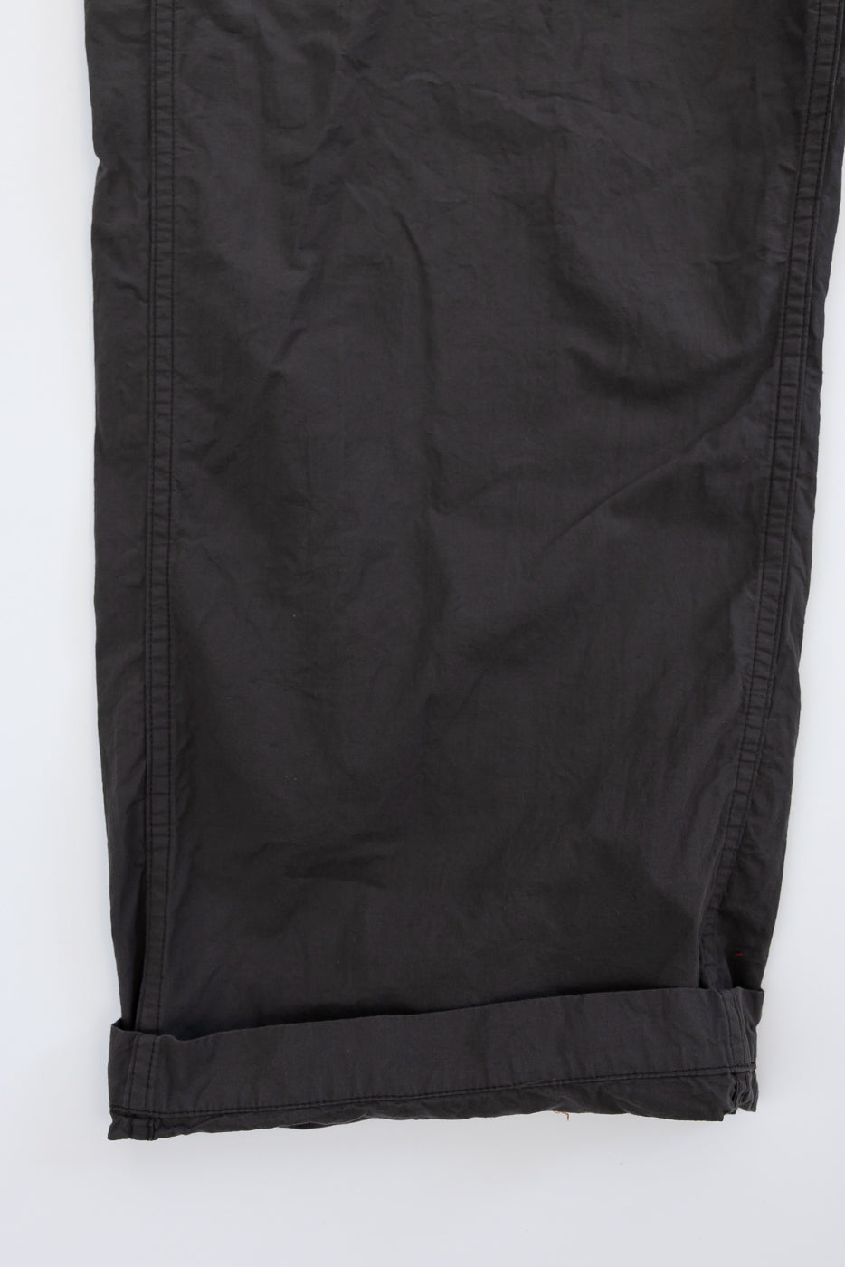 Black casual pants flat lay, front view, cuffed hem detail, lightweight fabric texture