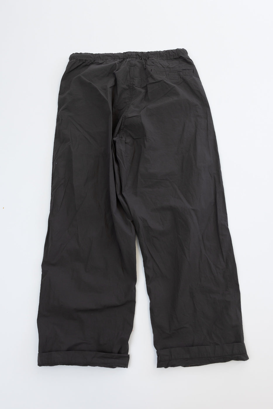 Black wide-leg pants back view, flat lay, elastic waist, cuffed hems, relaxed fit