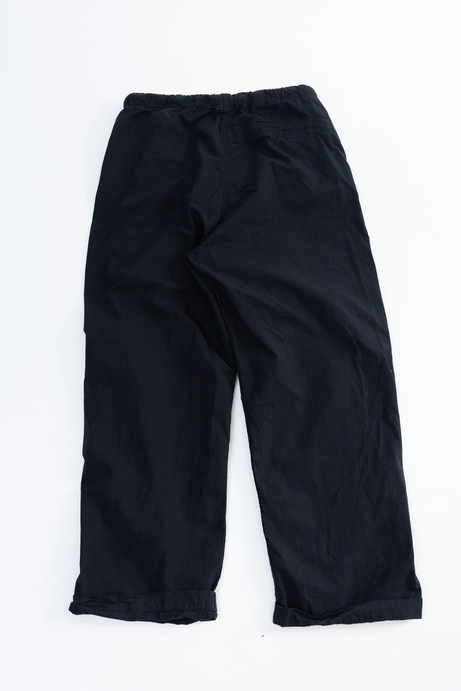 Black wide-leg casual pants, back view flat lay, elastic waist, cuffed hems, relaxed fit