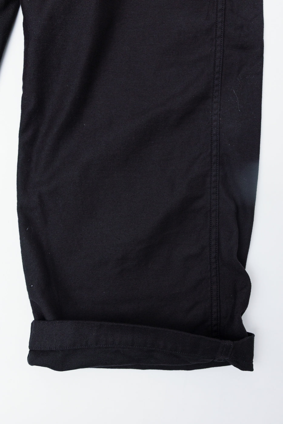 Close-up of orSlow black wide fit New Yorker pants hem, side view showing cuff and stitching