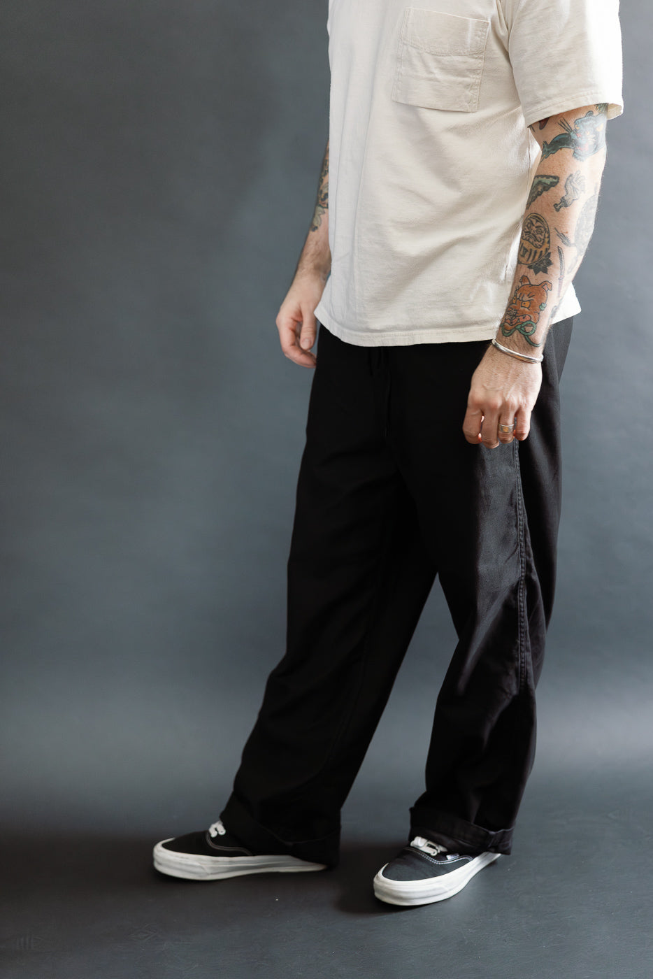 Wide fit black pants on male model, 5'9