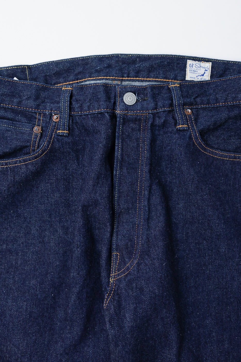 Close-up front view of orSlow 1950s selvedge denim jeans, button, tag, and waistband detail.