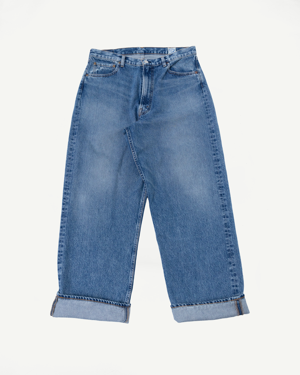 Front view flat lay of light wash blue denim jeans with cuffed hems.