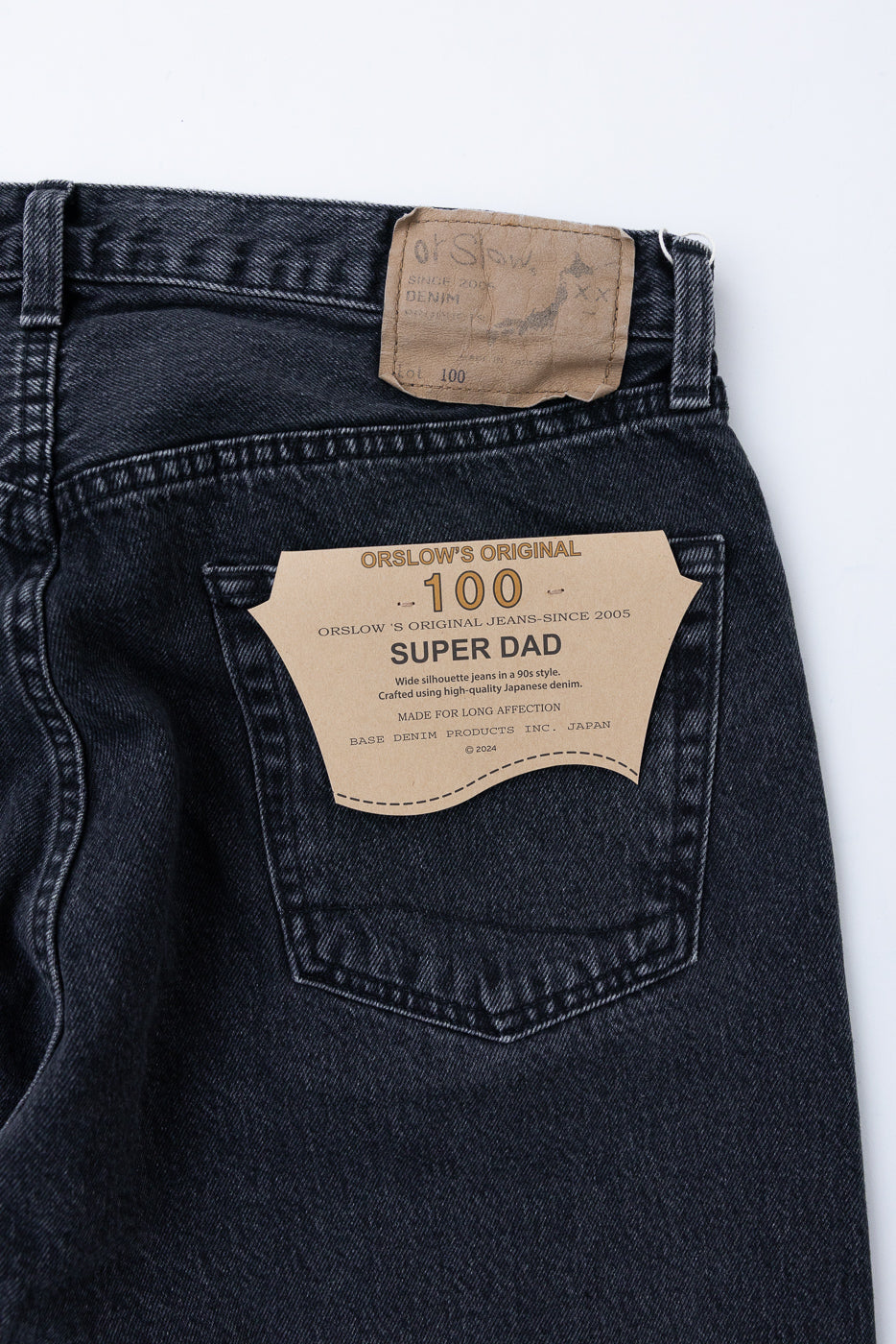 Close-up back view of dark wash denim jeans showing the waist patch and OrSlow Super Dad label.