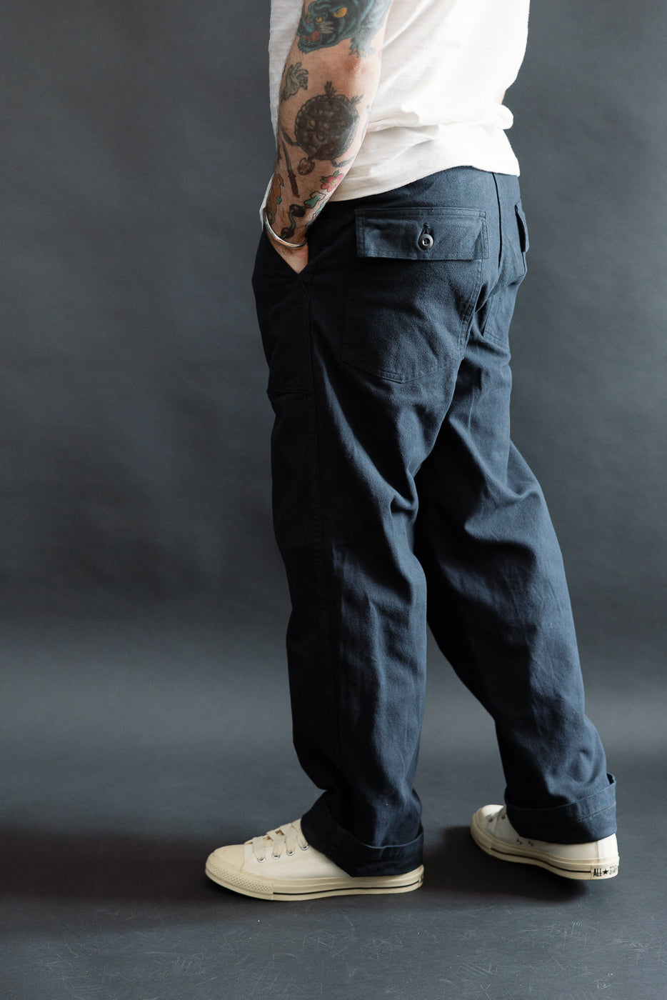 Male model 5'9 165lbs athletic build wearing dark navy brushed flannel fatigue pants, back side view, showing pocket and fabric details at Dant Indianapolis