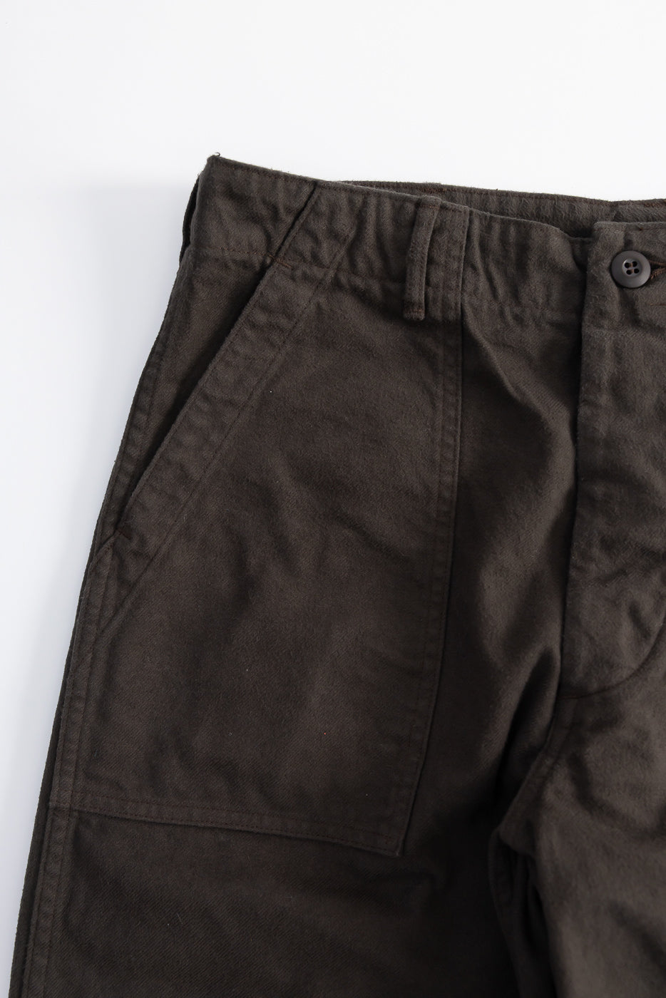 Close-up front view of Orslow coffee brown brushed flannel fatigue pants pocket, button, waistband detail.
