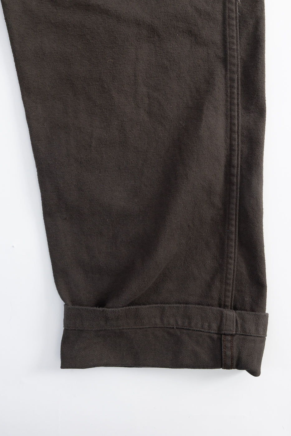 Close-up of Orslow coffee brown brushed flannel fatigue pants hem, showcasing fabric texture and stitching detail, front side.