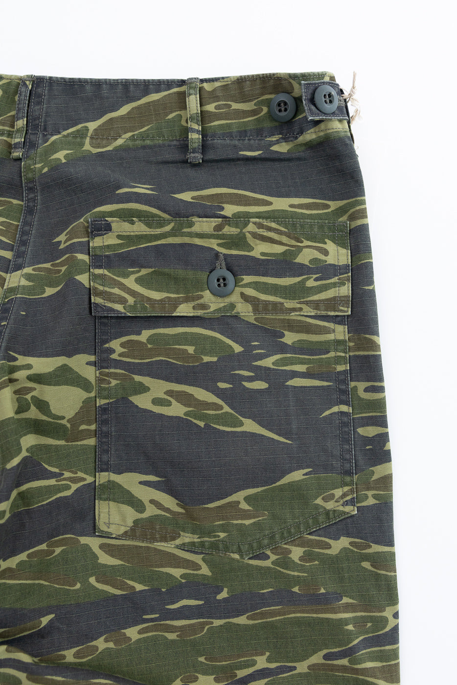 Close-up of 01-5002-TGC Fatigue Pants Ripstop Standard Fit - Tiger Camo, showcasing back cargo pocket with buttoned flap, waistband with belt loops, and two top buttons, highlighting their robust ripstop texture.