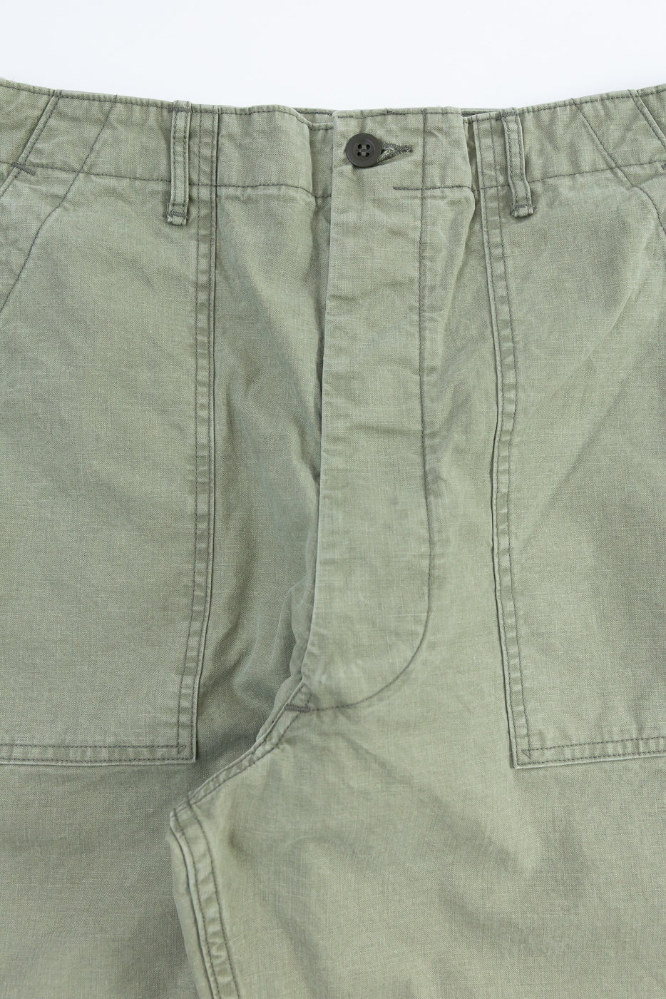 Close-up front view of olive green casual pants, showing button fly, belt loops, and fabric texture