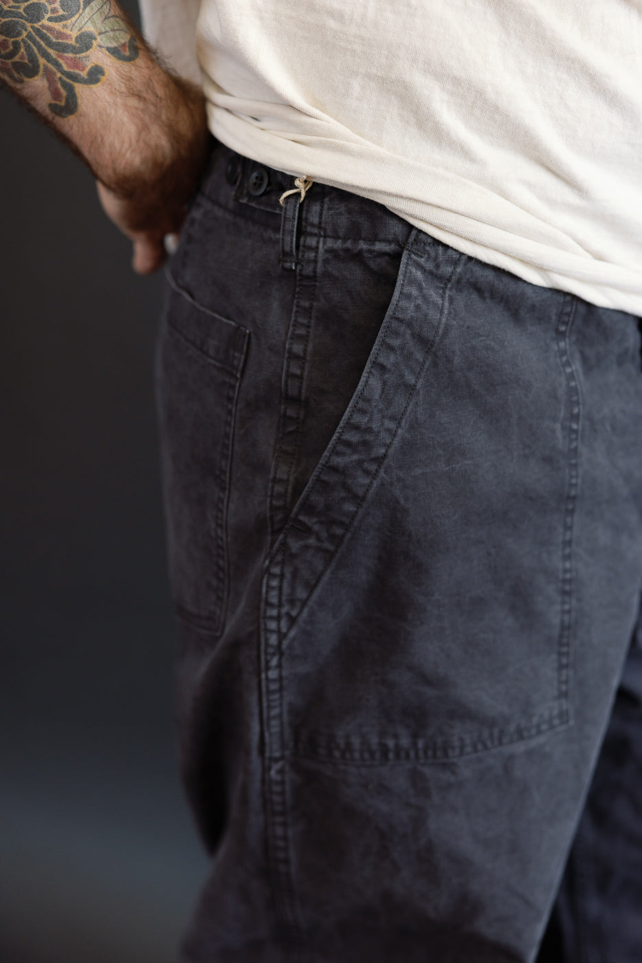 Close-up of the orSlow 01-5103-M61K Duck Canvas Summer Fatigue Pants in black, highlighting the charcoal-grey cargo style with a large side pocket and visible belt loops.