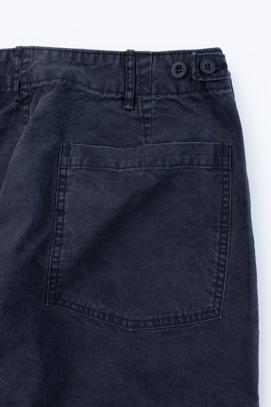 Close-up of the 01-5103-M61K - Duck Canvas Summer Fatigue Pants - Black, showcasing the rear right patch pocket, adjustable waistband with dual dark buttons, and worn-in texture.