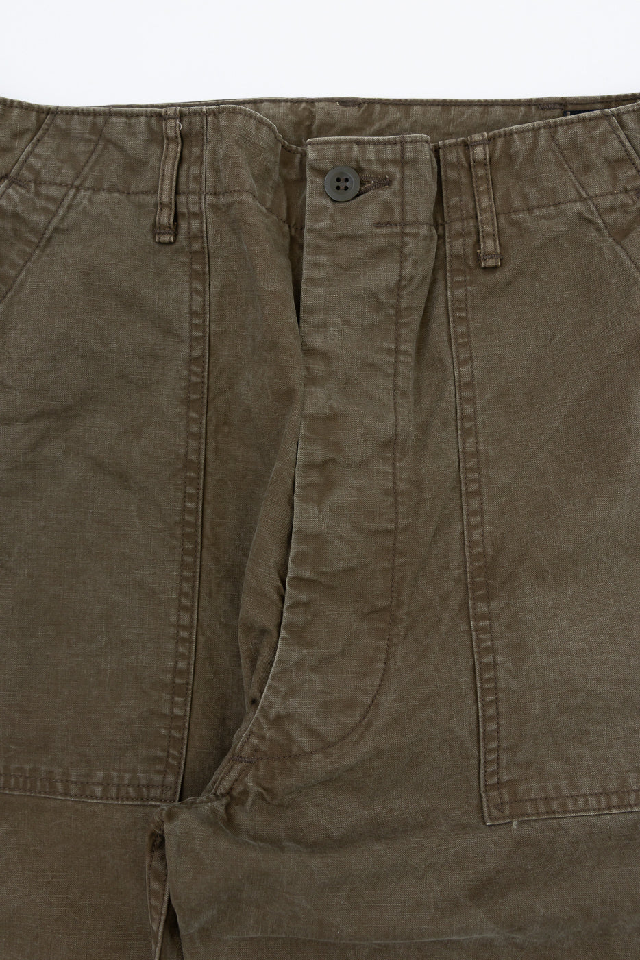 Close-up front view of olive cargo pants showing button fly, stitching, and fabric texture