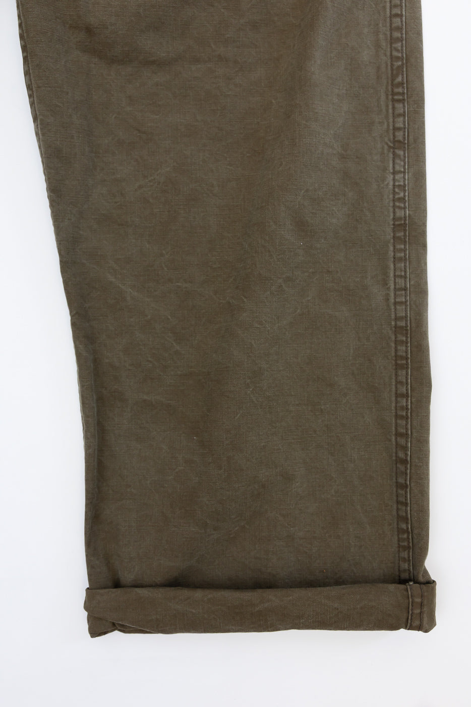 Close-up front view of olive green casual pants with rolled hem and side seam detail