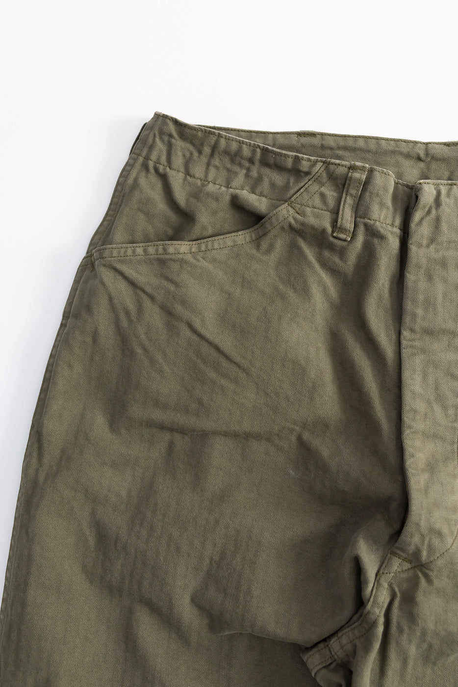 Close-up of orSlow USMC herringbone wide fit utility trousers, front left pocket, olive green, textured cotton fabric