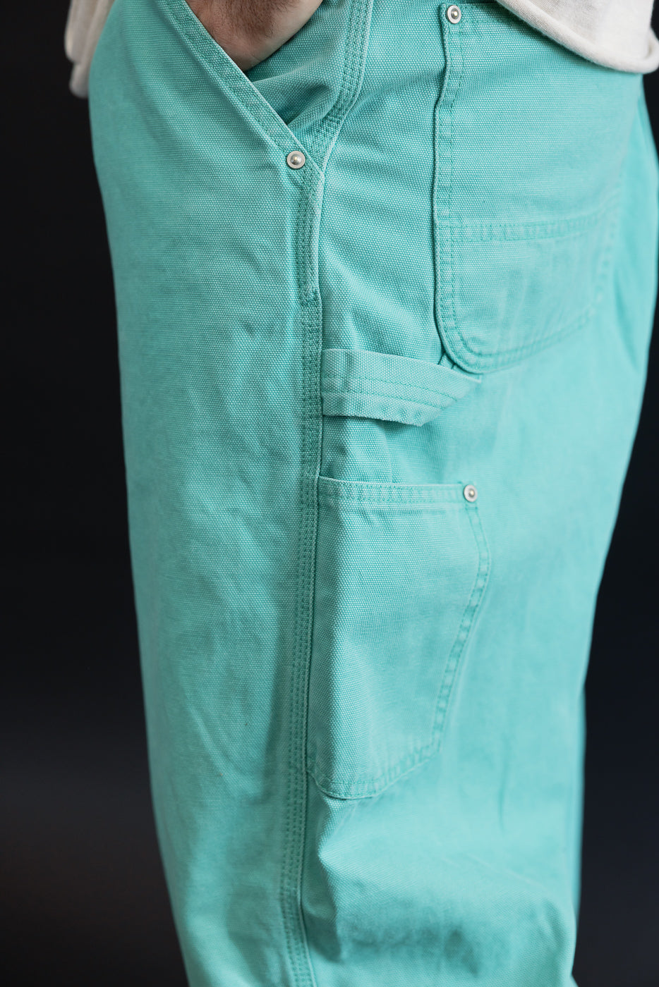 Close-up of 01-5328-39SK - Dad's Fit Painter's Pants Canvas - Turquoise, showcasing teal color, side-seam pockets, tool loop, and brass rivet details, highlighting durable design and worn-in texture.