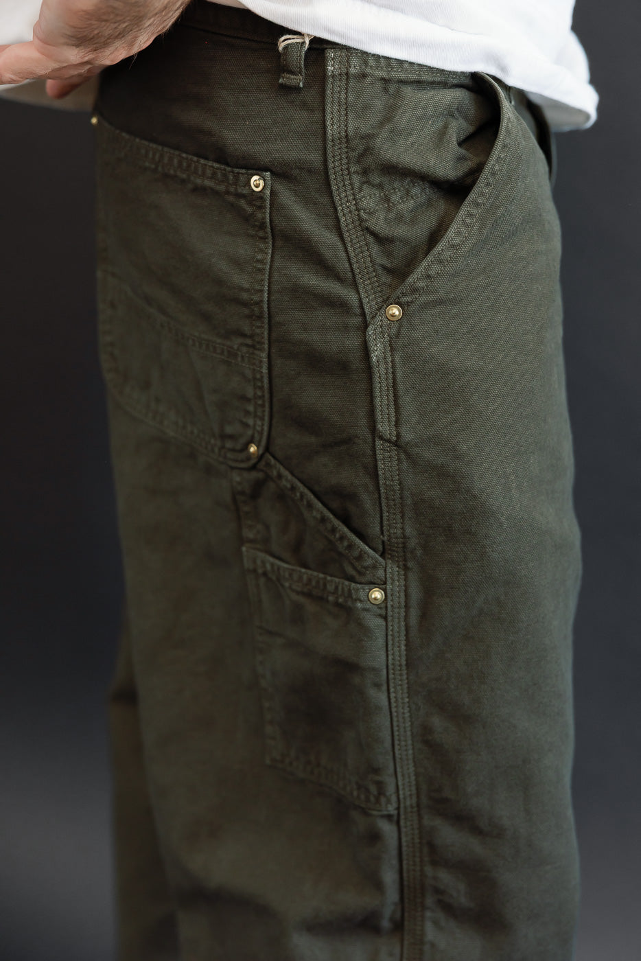 Close-up of the left side of olive green pants on a male model, 5'9