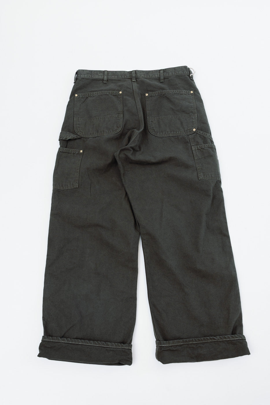 Flat lay of the back of charcoal grey wide-leg carpenter pants with back pockets and cuffed hems.