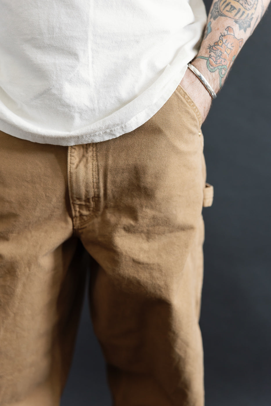 Close-up front view of men's canvas brown painter pants on 5'9