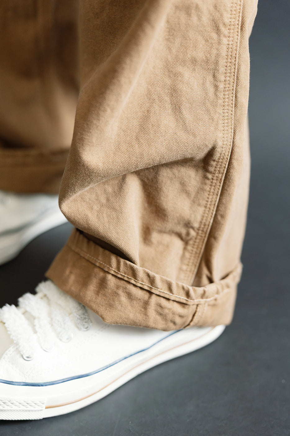Close-up of canvas brown painter pants hem detail, side view, styled on male model, Dant
