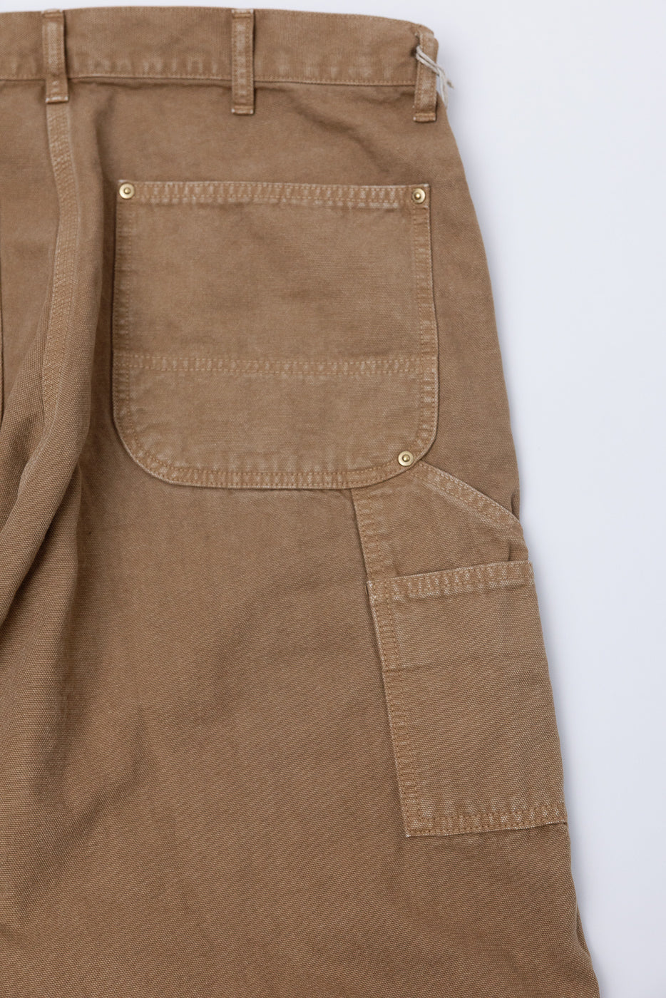 Close-up of orSlow Dad's Fit painters pants, brown canvas, back pocket and side tool pocket detail.