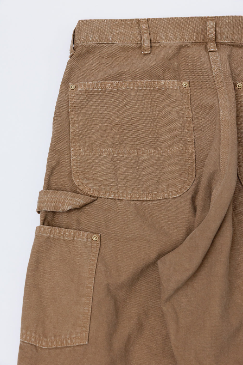 Close-up of orSlow Dad's Fit brown canvas painters pants back side, showing rear and side pockets detail, sturdy stitching, and utility loop.