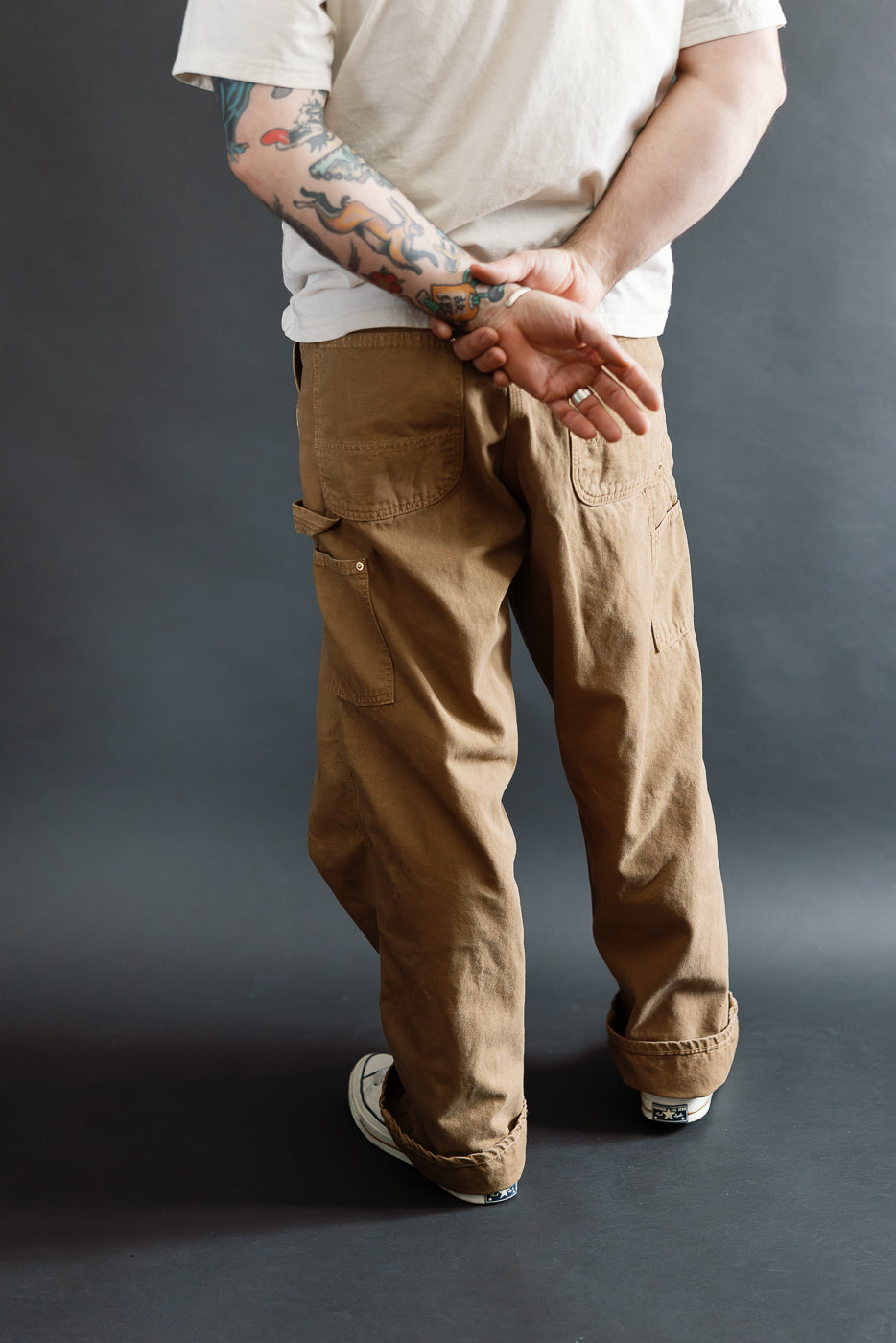Back view of brown canvas painters pants on male model, 5'9, 165lbs, athletic build, casual fit